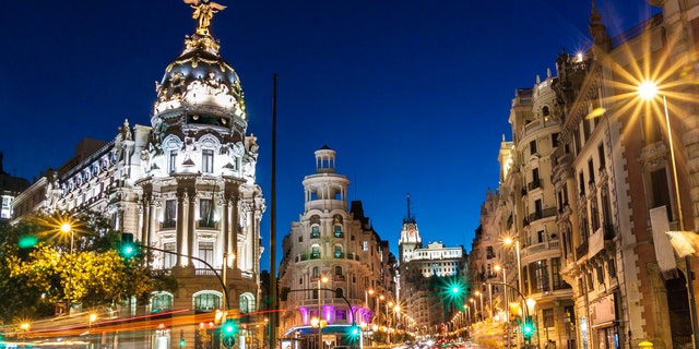Rays of traffic lights on Gran via street, main shopping street in Madrid at night. Spain, Europe.