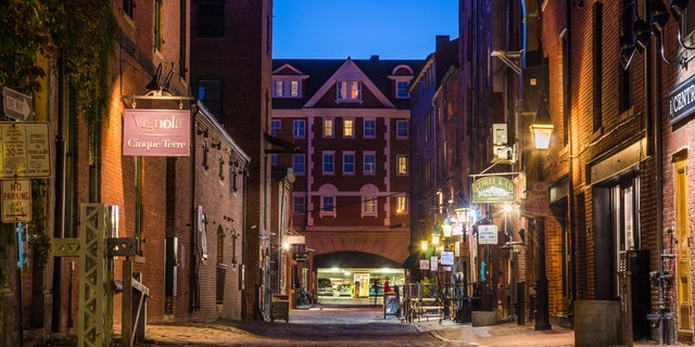 Portland, ME, USA - October 8, 2015: Cobbled Street Lined with shops and Pubs in the Old Port District at night. Portlandâs Old Port is one of the most successful revitalized warehouse districts in the country. Seamlessly connected to the waterfront, the Old Port is both a working waterfront and a local shopping, dining, residential, and entertainment district.