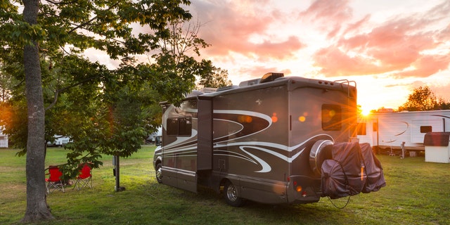 Road trip in motor home. North America. Motor home, camping at sunset. Lens flare.