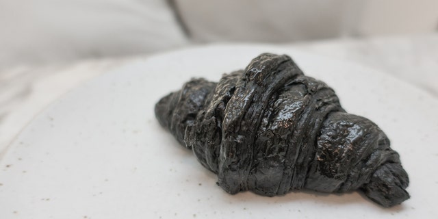 A cafe in London has debuted an activated charcoal vegan croissant that has some people losing their appetites.