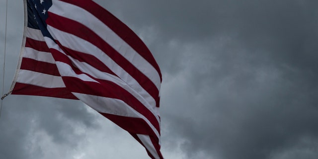 American Flag blowing in the wind of an approaching storm