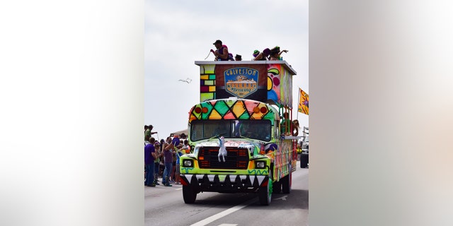 Galveston, USA - February 18, 2017: Galveston Island Brewery celebrates by tossing necklaces from a decorated bus during the Mardi Gras parade.