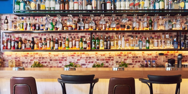 Shot of an immaculate bar with many bottles and glasses with no people
