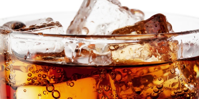 Fragment of glass cola with ice isolated on white background