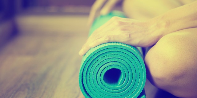 Young woman holding a yoga mat