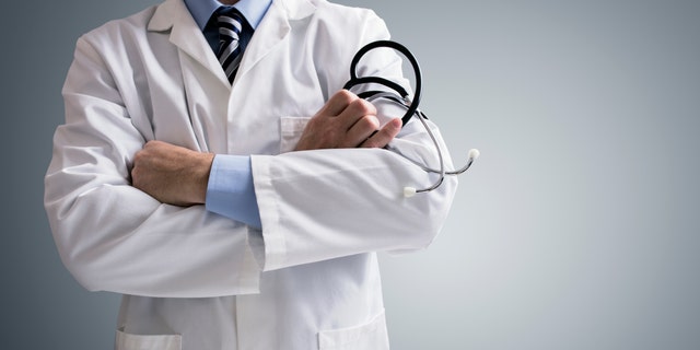 Doctor holding a stethoscope with arms crossed and copy space