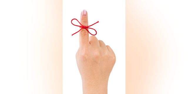 Red bow on finger isolated on white background