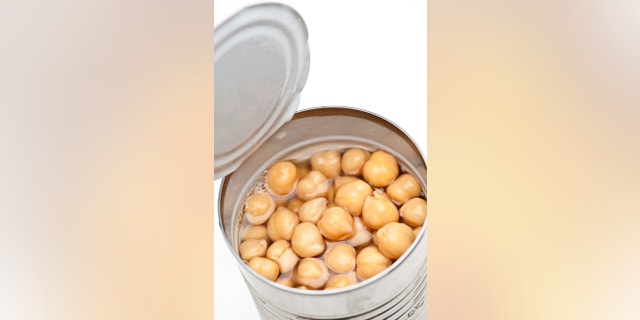 open can of garbanzo beans on white background