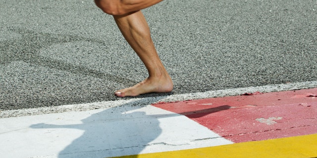 A closeup of a runners feet while barefoot running on a track