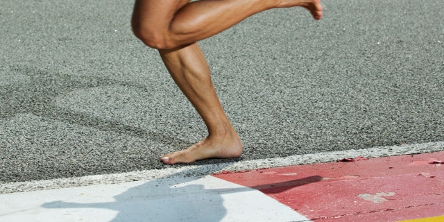 A closeup of a runners feet while barefoot running on a track