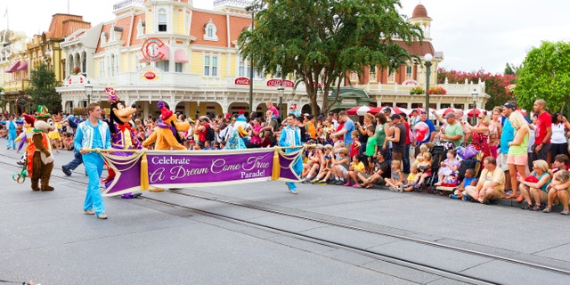 Orlando, USA - August 4, 2013: The start of the A Dream Come True Parade with Disney characters at a very crowded Main Street USA, the entrance to Magic Kingdom amusement park in Walt Disney World and the route of several parades during the day.
