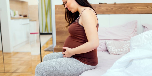 Pregnant woman having belly ache and cramps , spasms