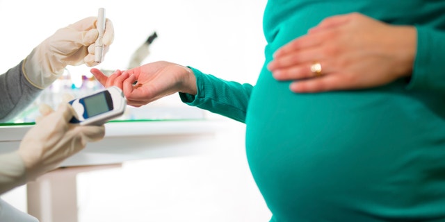 A close-up of a pregnant woman having her blood sugar/ glucose checked.