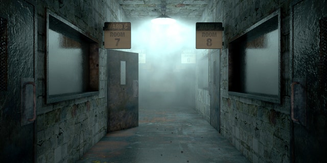 An eerie haunted look down the dimly lit passage of a dilapidated mental asylum with rooms and signs
