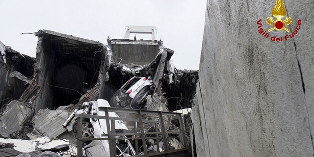 In this photo released by the Italian firefighters, cars are seen among the rubble of the collapsed Morandi highway bridge in Genoa, northern Italy on Tuesday.