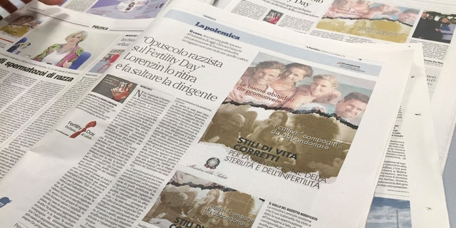 A journalist lays out newspapers reporting the Italian Health Ministry's "Fertility Day" campaign ad showing four light-skinned adults at the beach illustrating "good habits" for reproductive health, over a group of young people, including a black man, smoking, in Rome, Thursday, Sept. 22, 2016. Italy's efforts to combat infertility and reverse one of Europe's lowest birthrates have stumbled with an ad campaign denounced as sexist, racist and ignorant of the economic reasons why Italians aren't having babies. The ad was removed by the ministry after being denounced as racist.
