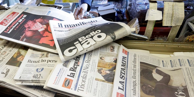Newspaper headlines show Italian Premier Matteo Renzi's resignation following the result of Sunday's constitutional referendum, at a newsstand in Rome, Monday, Dec. 5, 2016. Italian voters dealt Premier Renzi a resounding rebuke early Monday by rejecting his proposed constitutional reforms, plunging Europe's fourth-largest economy into political and economic uncertainty. (AP Photo/Gregorio Borgia)