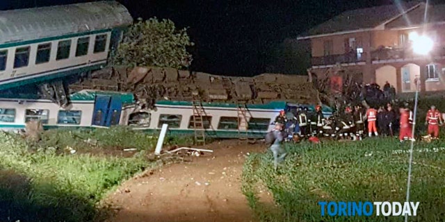 Firefighters and rescue personnel swarm the site of the wreck near Turin early Thursday.