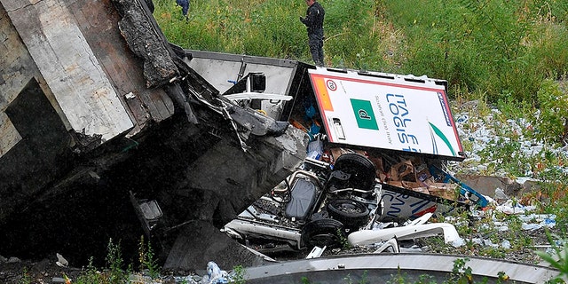 Rescuers work among the debris of the collapsed Morandi highway bridge in Genoa.