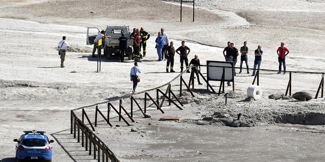 Rescuers stand on the site where three people reportedly died when they fell into a crater in a steamy volcanic field.