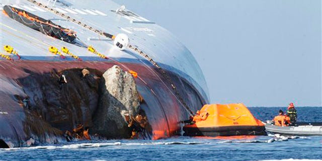 Jan. 24, 2012: Oil recovery experts work near the hole of the grounded cruise ship Costa Concordia off the Tuscan island of Giglio, Italy.