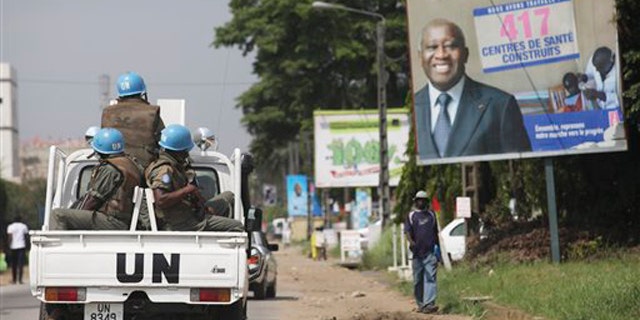 Dec. 23, 2010: U.N. forces drive past a billboard for President Laurent Gbagbo in Ivory Coast, Abidjan. The United Nations said Thursday that at least 173 people have been killed and dozens of others have gone missing or been tortured following Ivory Coast's disputed presidential election, which has prompted fears of a return to civil war.