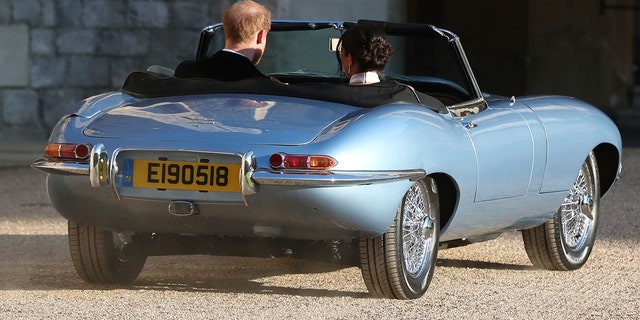 The newly married Duke and Duchess of Sussex, Meghan Markle and Prince Harry, leave Windsor Castle in a convertible car after their wedding in Windsor, England, to attend an evening reception at Frogmore House, hosted by the Prince of Wales, Saturday, May 19, 2018. (Steve Parsons/pool photo via AP)