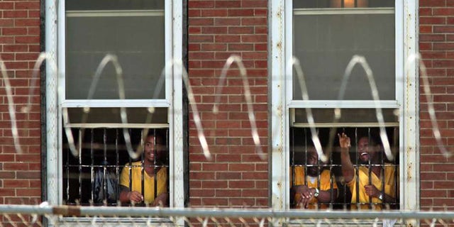 Inmates watch the arrival of temporary air conditioning units at the St. Louis Medium Security Institution.