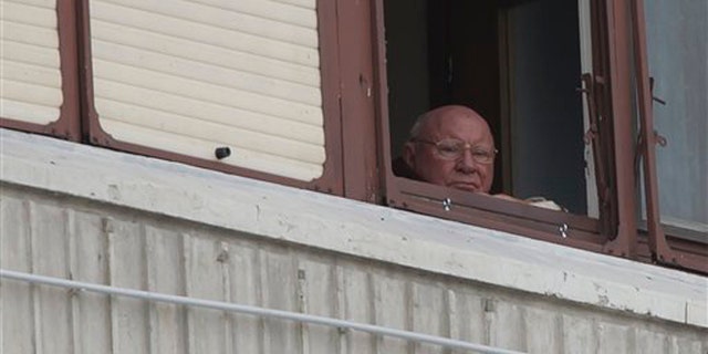 In this July 28, 2014, photo, Jakob Denzinger looks from his apartment window in Osijek, eastern Croatia. The suspected former Nazi prison guard at Auschwitz and other death camps, Jakob Denzinger, has died in his native Croatia at the age of 92. (AP Photo/Darko Bandic)