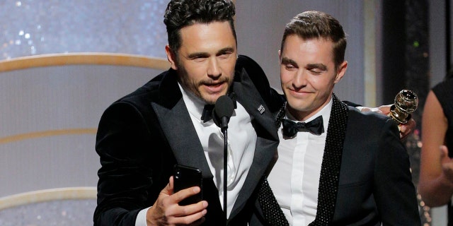 James Franco accepts the award for Best Actor in a Comedy or Musical at the 75th annual Golden Globes with brother Dave Franco.
