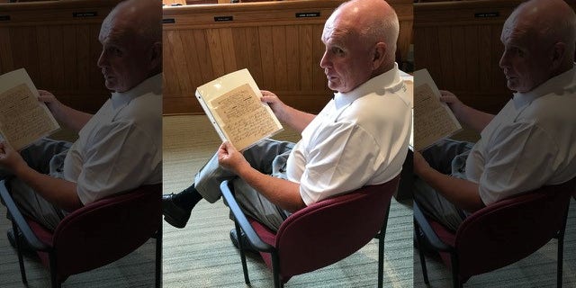 Reis holding the deed to the land at Sixth and Market Street that would later became the first presidential mansion for George Washington.