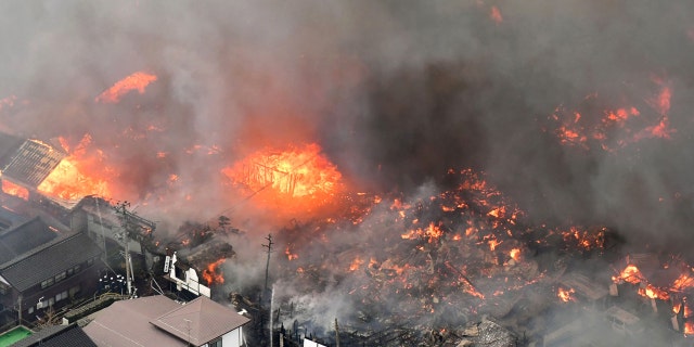 Smoke billow from houses during a fire in Itoigawa, northern Japan, Thursday, Dec. 22, 2016.