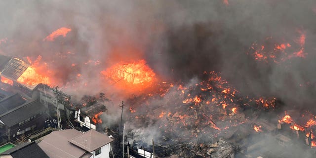 Smoke billow from houses during a fire in Itoigawa, northern Japan, Thursday, Dec. 22, 2016. A fire whipped by high winds has spread to at least 140 buildings in a small Japanese city on the Japan Sea coast. The fire department says the blaze started at a restaurant in Itoigawa city Thursday morning. By mid-afternoon, 140 houses and other buildings had caught fire, and the fire is still spreading. (Kyodo News via AP)