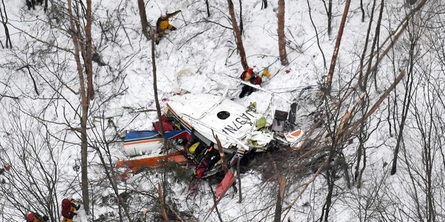 Rescuers work near the helicopter crashed in mountains in Nagano prefecture, central Japan Sunday, March 5, 2017. The rescue helicopter carrying nine people has crashed in snow-coved mountains during a training flight.