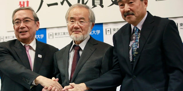 Nobel Prize winner Yoshinori Ohsumi, center, poses with Tokyo Institute of Technology President Yoshinao Mishima, left, and its Excutive Vice President Makoto Ando after a press conference at the Tokyo Institute of Technology in Tokyo Monday, Oct. 3, 2016. Ohsumi won the Nobel Prize in medicine on Monday for discoveries on how cells break down and recycle content, a garbage disposal system that scientists hope to harness in the fight against cancer, Alzheimerâs and other diseases