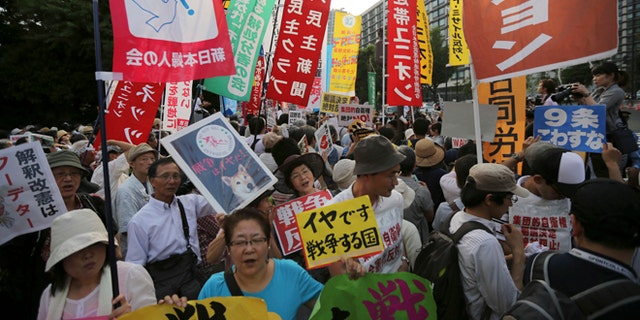 July 1, 2014: Protesters shout slogans outside the Japanese Prime Minister Shinzo Abe's official residence in Tokyo as Abe's Cabinet approved reinterpreting the constitution on military affairs.