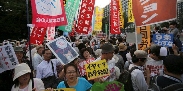 July 1, 2014: Protesters shout slogans outside the Japanese Prime Minister Shinzo Abe's official residence in Tokyo as Abe's Cabinet approved reinterpreting the constitution on military affairs.