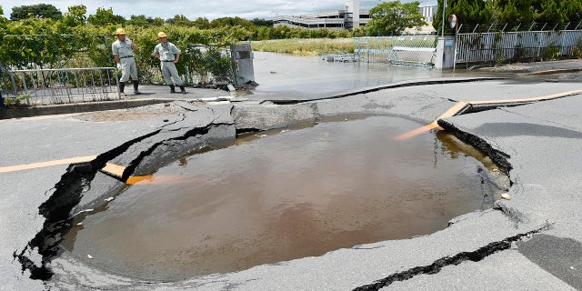 A collapsed road is filled with water after water pipes broke following an earthquake in Takatsuki city, Osaka, western Japan, June 18, 2018.
