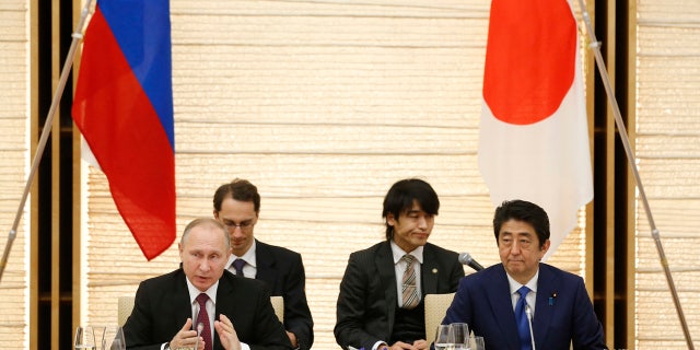 Russian President Vladimir Putin, left, and Japanese Prime Minister Shinzo Abe, right, attend a working lunch in Tokyo, Japan, Friday, Dec. 16, 2016.