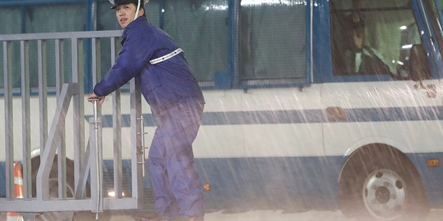 A policeman stands guard in the heavy rain outside the headquarters of Japan's ruling Liberal Democratic Party in Tokyo.