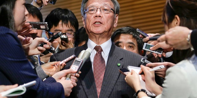 FILE - In this March 4, 2016 file photo, Okinawa Gov. Takeshi Onaga is surrounded by reporters after a meeting with Japanese Prime Minister Shinzo Abe at the latter's official residence in Tokyo.  Japan and the U.S. have marked a partial return of the land used by American troops to Okinawa in a ceremony on the southern island Thursday, Dec. 22, 2016, , but there was no sign the move was helping to lessen protests against the heavy U.S. military presence. Demanding an unconditional land return, Okinawa Gov. Onaga skipped Thursdays ceremony and joined a protest. (Kimimasa Mayama/Pool Photo via AP, File)