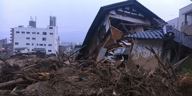 Debris fills a small village following heavy rains Sunday, July 8, 2018, in Kuchita-Minami, Asakita-ku, Hiroshima, Japan. Searches continued Sunday night for dozens of victims still missing from the heavy rainfall that hammered southern Japan for the third straight day. (AP Photo Haruka Nuga)