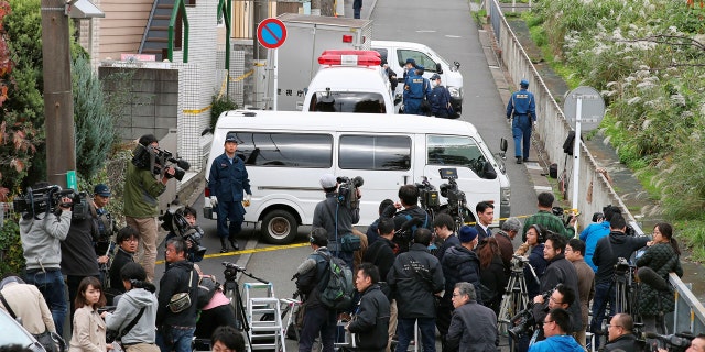 Members of the media gather near an apartment building where the severed remains of nine bodies were reportedly found.