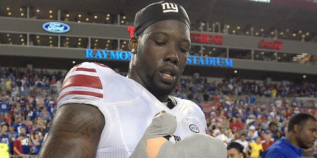 New York Giants defensive end Jason Pierre-Paul removes the bandage from his damaged hand after the Giants defeated the Tampa Bay Buccaneers 32-18 during an NFL football game Sunday, Nov. 8, 2015, in Tampa, Fla. (AP Photo/Phelan M. Ebenhack)