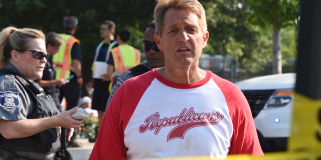 Sen. Jeff Flake, R-Ariz. walks toward media gathered at the scene of a shooting at a baseball field in Alexandria, Va., Wednesday, June 14, 2017, during a Congressional baseball practice where House Majority Whip Steve Scalise of La. was shot. (AP Photo/Kevin S. Vineys)