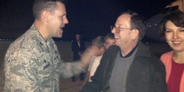 Jeffrey Fowle, (center), and his wife Tatyana were greeted by Air Force Col. John Devillier upon Fowle's arrival on American soil, on Oct. 22, 2014.