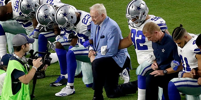 Dallas Cowboys owner Jerry Jones kneels with his players before an NFL game last season.