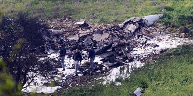 Investigators inspect the wreckage of an F-16 that crashed in northern Israel.