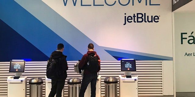 Travelers check-in at a JetBlue Airways kiosk at John F. Kennedy Airport in the Queens borough of New York, U.S., January 24, 2017.