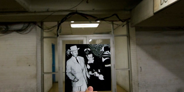 This September 10, 2013 photo shows a picture taken by Bob Jackson of the Dallas Times Herald on November 24, 1963, of Lee Harvey Oswald, assassin of US President John F. Kennedy, reacting as the owner of the Dallas Night Club, Jack Ruby in the foreground shot at close range in a hallway of Dallas Police Headquarters, juxtaposed to the current scene at Dallas Police Headquarters. (Associated Press)